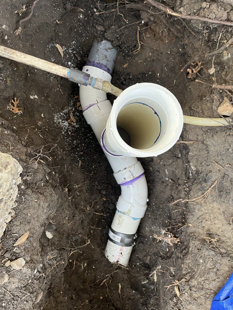 PVC sewer line repair exposed in an excavation